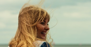Girl enjoying summer breeze by seaside