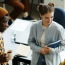 drie collega's staan op werk met elkaar te kletsen
