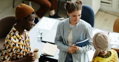 drie collega's staan op werk met elkaar te kletsen