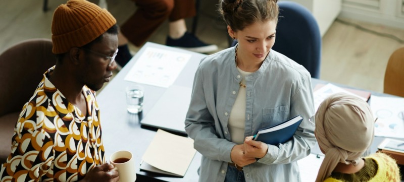 drie collega's staan op werk met elkaar te kletsen