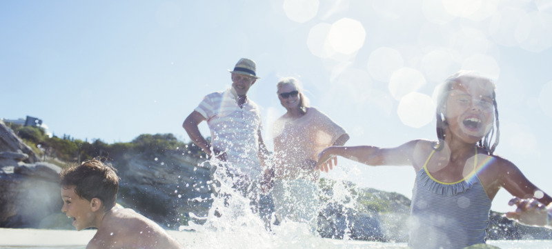 Family splashing each other on beach