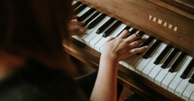 een foto van iemand die piano speelt ter illustratie bij een advies over autisme en hoogbegaafdheid