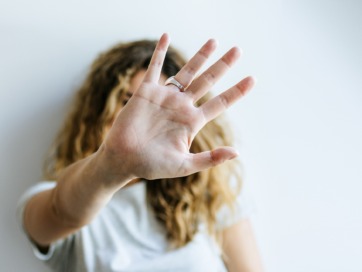 vrouw doet haar hand in een stokteken als teken dat ze opgeeft