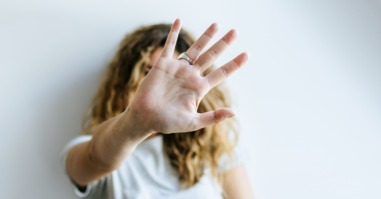 vrouw doet haar hand in een stokteken als teken dat ze opgeeft