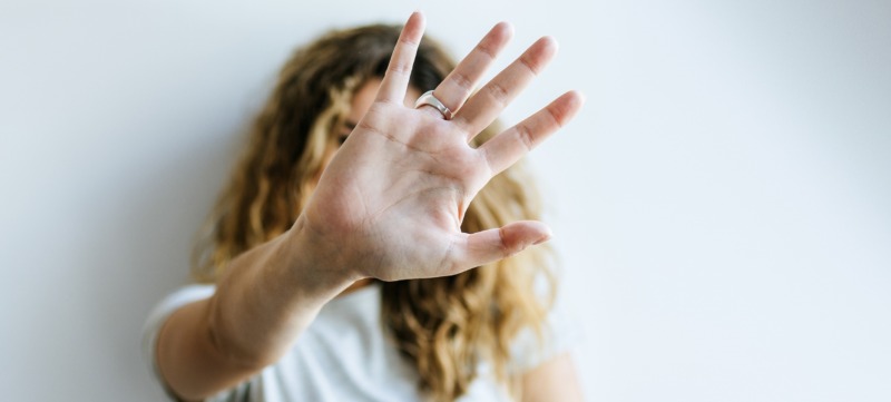 vrouw doet haar hand in een stokteken als teken dat ze opgeeft