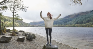 Woman laughing by the side of a loch