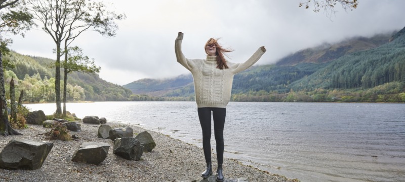 Woman laughing by the side of a loch