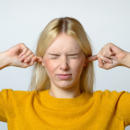 Disgusted Woman Covering her Ears with Fingers