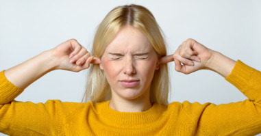Disgusted Woman Covering her Ears with Fingers