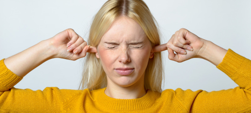 Disgusted Woman Covering her Ears with Fingers