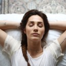 A young woman laying on her bed