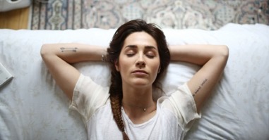 A young woman laying on her bed