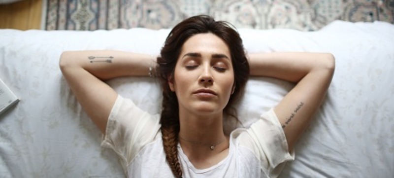 A young woman laying on her bed