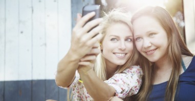two adult female friends hanging out and having fun taking a selfie