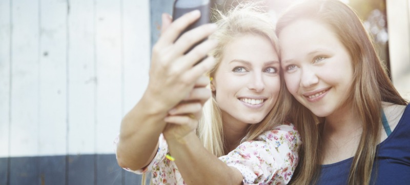 two adult female friends hanging out and having fun taking a selfie