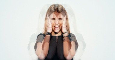 vrouw houdt oren voor haar hoofd ter bescherming van de piep in haar oren