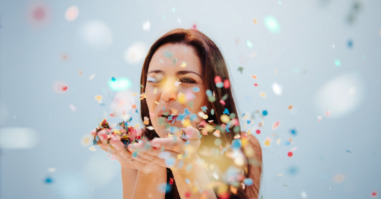 Close up view of a woman blowing confetti