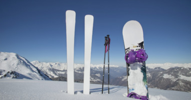 Skis and snowboard stuck in the snow