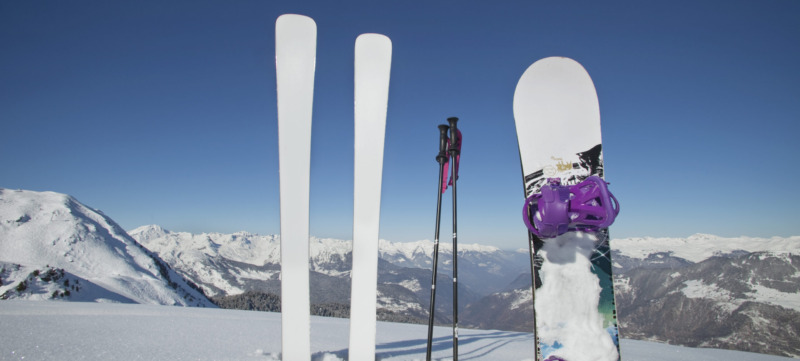 Skis and snowboard stuck in the snow