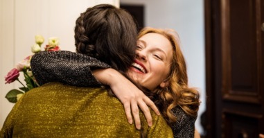 Woman embracing friend during visit for dinner party
