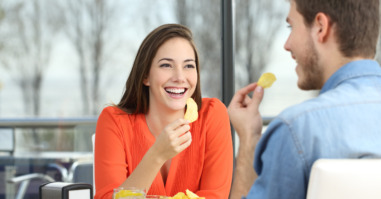 Couple talking and eating chip potatoes