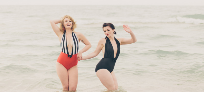 Two Beautiful Young Women in Retro Vintage Swimsuits at Beach