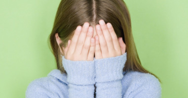 Studio shot portrait of teenage girl covering face, head and shoulders