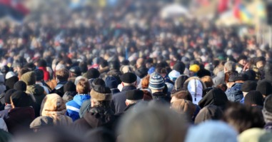 Crowd of anonymous people on street in city center, selective focus