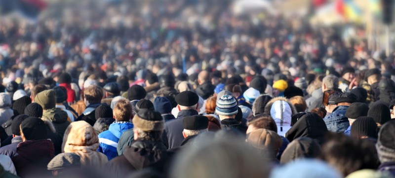 Crowd of anonymous people on street in city center, selective focus