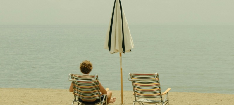 man zit aan het strand op vakantie