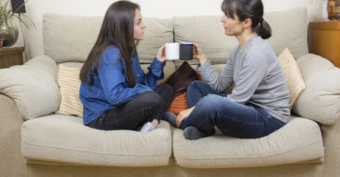 Mother and daughter sitting on a couch
