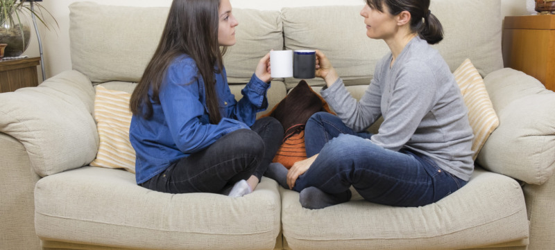 Mother and daughter sitting on a couch