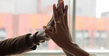 Een high five van drie mensen tegelijk.