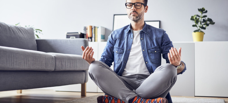 Relaxed man meditating at home