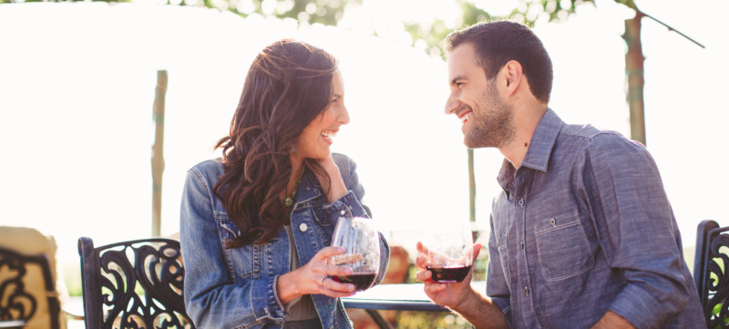 Couple enjoy glasses of wine at outdoor bar