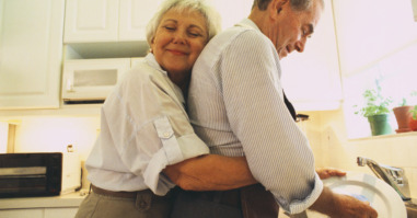 Woman Hugging Her Husband in Their Kitchen