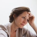 Depressed woman with head in hands