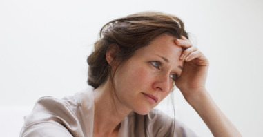 Depressed woman with head in hands