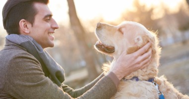 Happy man petting his cheerful dog