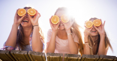 Teen girl friends holding up oranges for eyes
