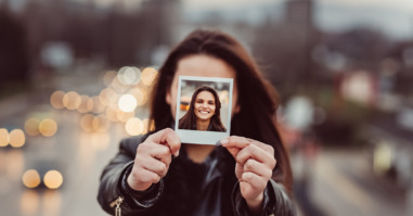 Young woman showing instant selfie