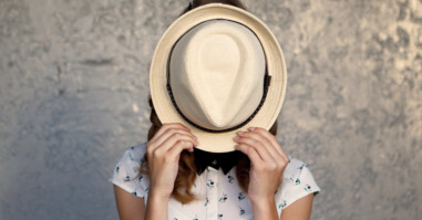 Young girl with hat. Hides her face.Depression.