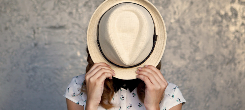Young girl with hat. Hides her face.Depression.