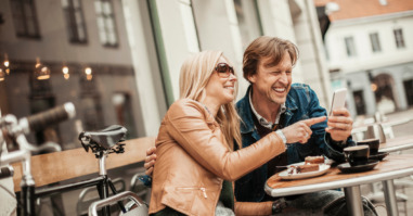 Happy mature couple using mobile phone