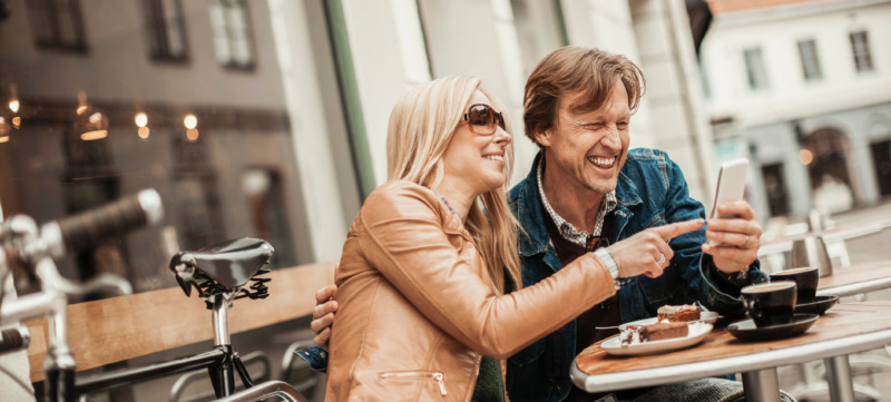Happy mature couple using mobile phone