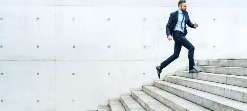 Young businessman running on stairs in the street