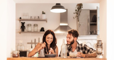 Young couple eating together at home