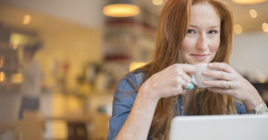 Woman using laptop in cafe