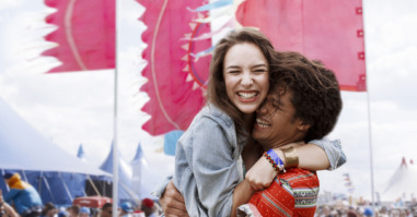 Enthusiastic couple hugging at music festival