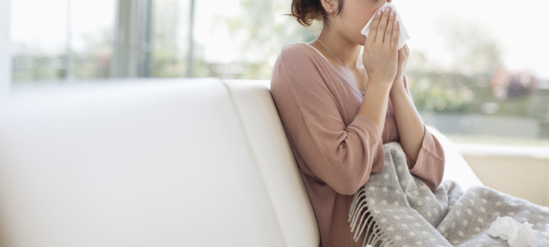 Sick woman blowing her nose